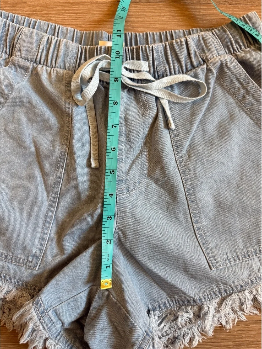 Pull on drawstring, casual light wash denim shorts for women raw hem size Medium